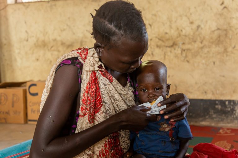 Gesundheitszentrum im Südsudan, Frauen füttert Kleinkind