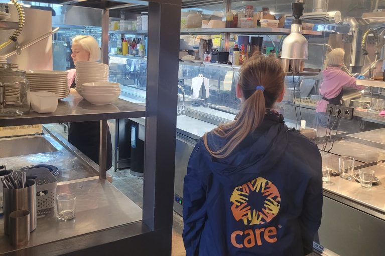 Sarah Easter mit CARE Jacke, in Küche, Kiew Ukraine